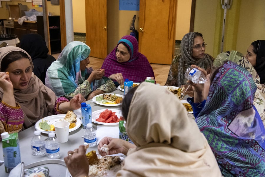 A group of women chat while eating iftar, the post-sunset meal during Ramadan, at the Islamic Society of Southwest Washington in Hazel Dell. Nighttime is also when practicing Muslims get their fill of water and other beverages.