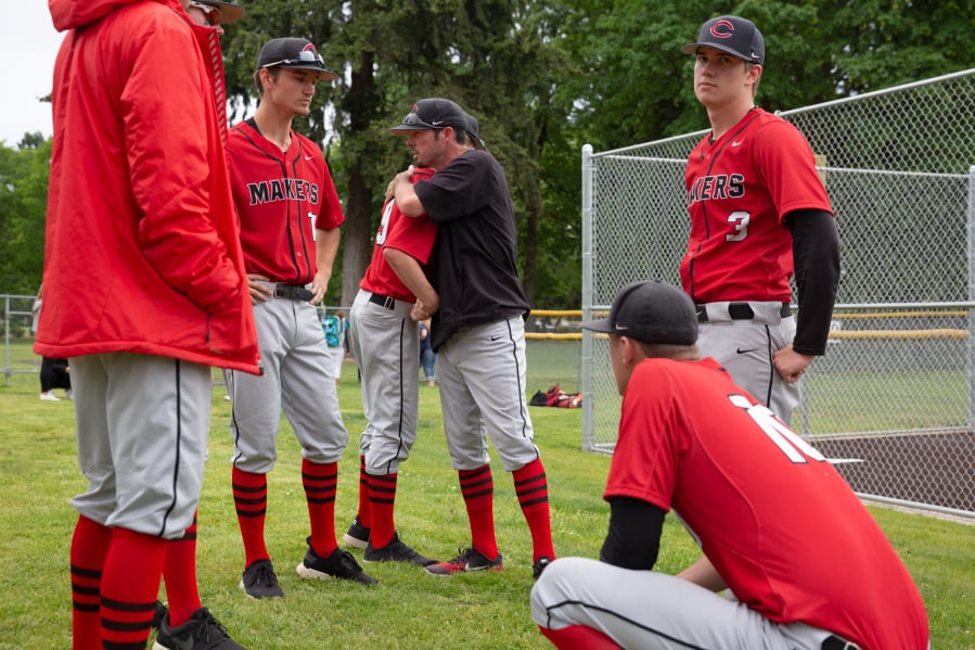 Camas head coach Stephen Short, center, consoles players after their loss to Issaquah at Propstra Stadium on Saturday afternoon, May 18, 2019. The Eagles defeated the Papermakers 5-1.