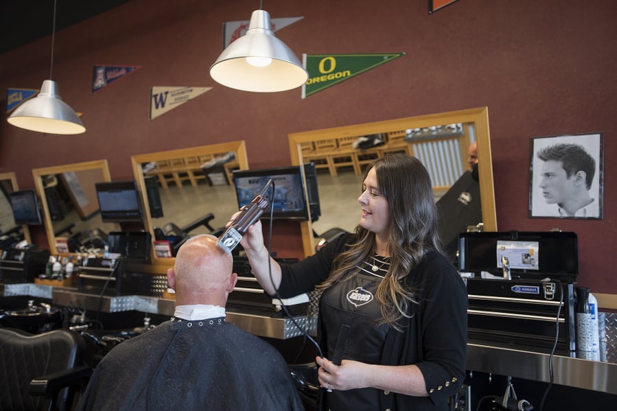 Camas resident Scott Binder stops by The Barbers to get a buzz cut and a neck shave from manager Tamie Brown.