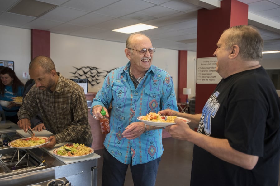 Darius Roberts, from left, a member of Recovery Cafe Clark County, makes his way through the salad bar at lunchtime as fellow member Cliff McFall shares a laugh with circle facilitator Monte Gantka. Recover Cafe Clark County offers free food to members. The cafe specializes in helping people recover from substance addiction, abuse, past trauma and more. “We don’t determine what recovery is for our members,” said Recovery Cafe Clark County Executive Director Larry Worthington.