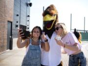 Haley Dewitz, 18, left, and Kelli Paterson, 17, both of Ridgefield, take a selfie with the Raptors mascot, Rally, who was named in honor of the nearby Ridgefield National Wildlife Refuge, just one of the many connections team officials have tried to make to Ridgefield.