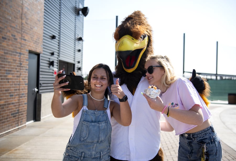 Haley Dewitz, 18, left, and Kelli Paterson, 17, both of Ridgefield, take a selfie with the Raptors mascot, Rally, who was named in honor of the nearby Ridgefield National Wildlife Refuge, just one of the many connections team officials have tried to make to Ridgefield.