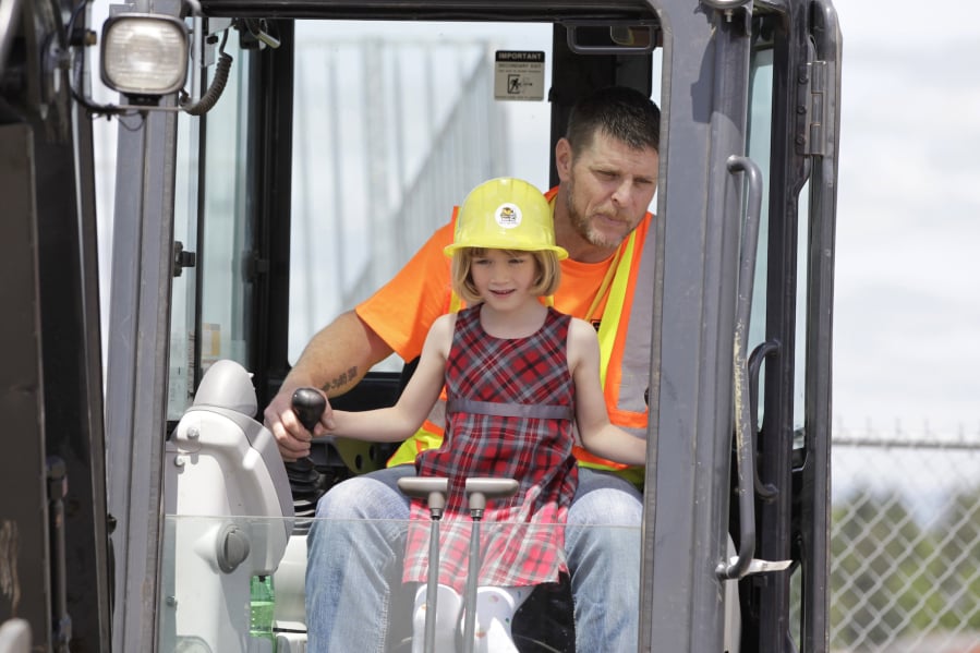 Liah Hansen-Bruen operates an excavator with help from Frank Lott at Dozer Day in 2019.