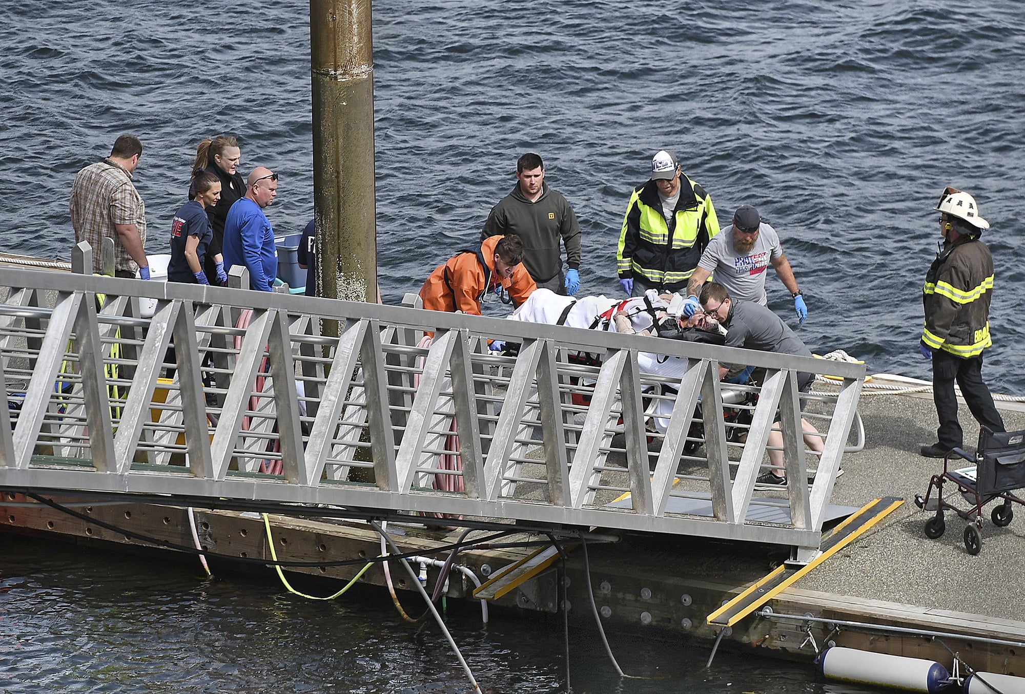 Emergency response crews transport an injured passenger to an ambulance at the George Inlet Lodge docks, Monday, May 13, 2019, in Ketchikan, Alaska. The passenger was from one of two sightseeing planes reported down in George Inlet early Monday afternoon and was dropped off by a U.S. Coast Guard 45-foot response boat.