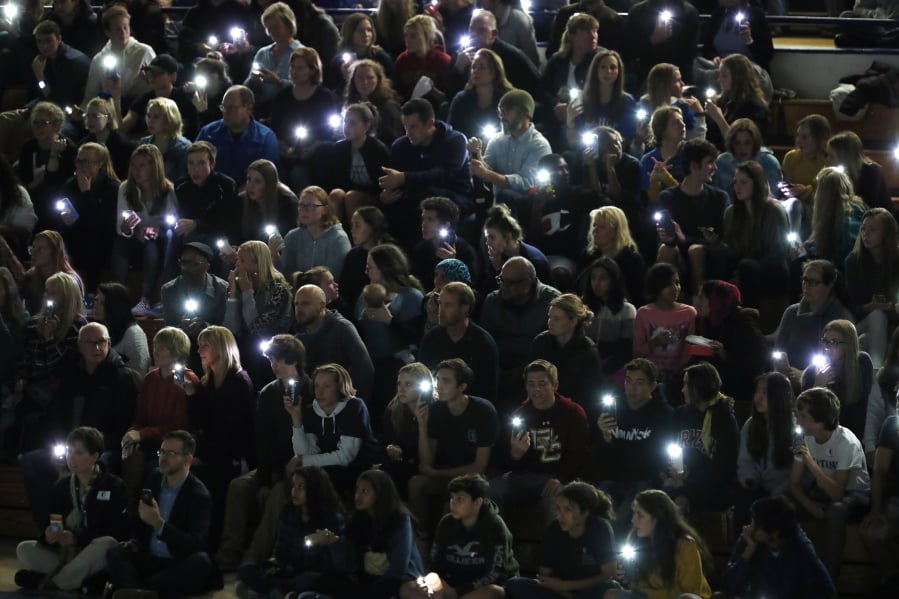 Attendees illuminate their mobile telephones during a community vigil to honor the victims and survivors of yesterday’s fatal shooting at the STEM School Highlands Ranch, late Wednesday, May 8, 2019, in Highlands Ranch, Colo.