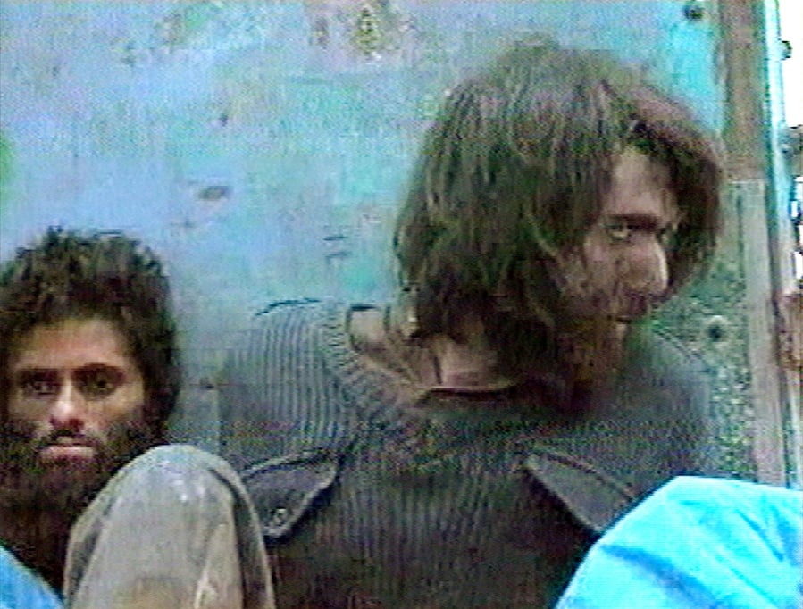 FILE - This file image taken Dec. 1, 2001, from television footage in Mazar-i-Sharif, Afghanistan, shows John Walker Lindh, right, claiming to be an American Taliban volunteer. Lindh, the young Californian who became known as the American Taliban after he was captured by U.S. forces in the invasion of Afghanistan in late 2001, is set to go free Thursday, May 23, 2019, after nearly two decades in prison.