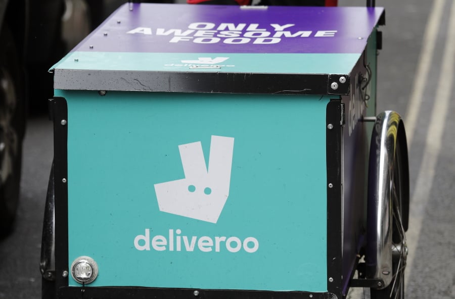 FILE - In this Tuesday, July 11, 2017 file photo, a Deliveroo logo is seen on a bicycle in London. Amazon is investing in British meal delivery company Deliveroo, expanding its reach into food retailing. Deliveroo said Friday May 17, 2019 that it raised $575 million from investors led by Amazon.