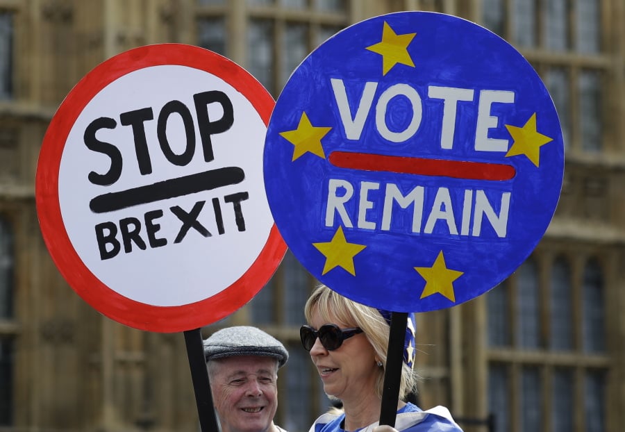 Anti Brexit campaigners hold banners near Parliament in London, Wednesday, May 22, 2019. British Prime Minister Theresa May was under pressure Wednesday to scrap a planned vote on her tattered Brexit blueprint — and to call an end to her embattled premiership — after her attempt at compromise got the thumbs-down from both her own Conservative Party and opposition lawmakers.