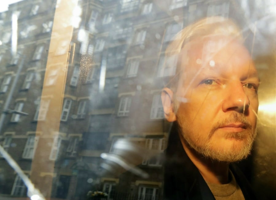 FILE - In this Wednesday May 1, 2019 file photo, buildings are reflected in the window as WikiLeaks founder Julian Assange is taken from court, where he appeared on charges of jumping British bail seven years ago, in London. Swedish prosecutors plan to decide whether they will reopen a rape case against WikiLeaks founder Julian Assange.