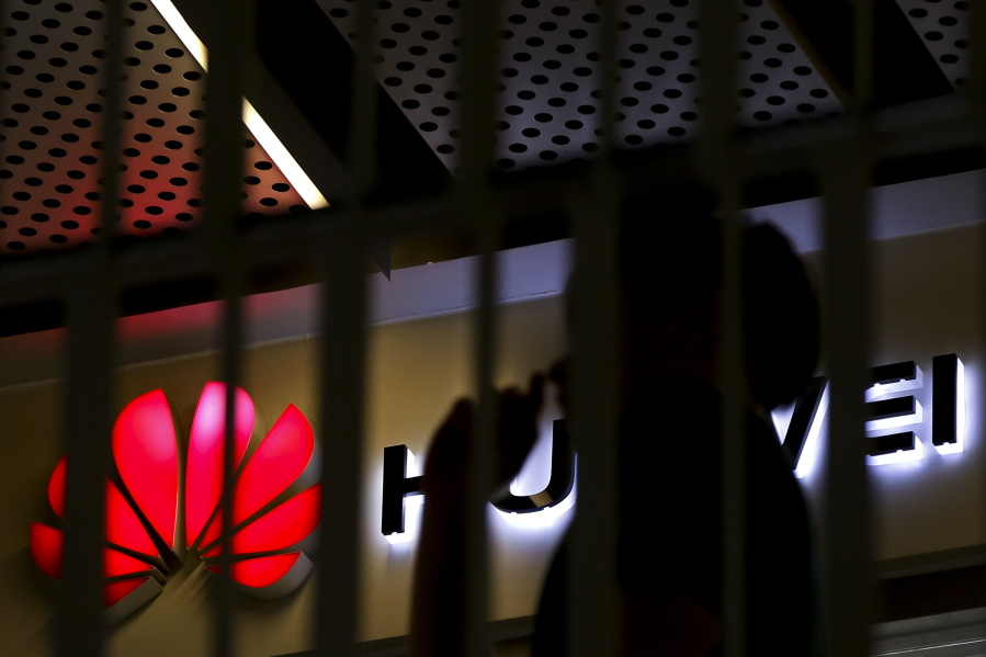 A man walks by a Huawei retail shop behind a handrail inside a commercial office building in Beijing, Tuesday, May 21, 2019. The Trump administration’s sanctions against Huawei have begun to bite even though their dimensions remain unclear. U.S. companies that supply the Chinese tech powerhouse with computer chips saw their stock prices slump Monday, and Huawei faces decimated smartphone sales with the anticipated loss of Google’s popular software and services.