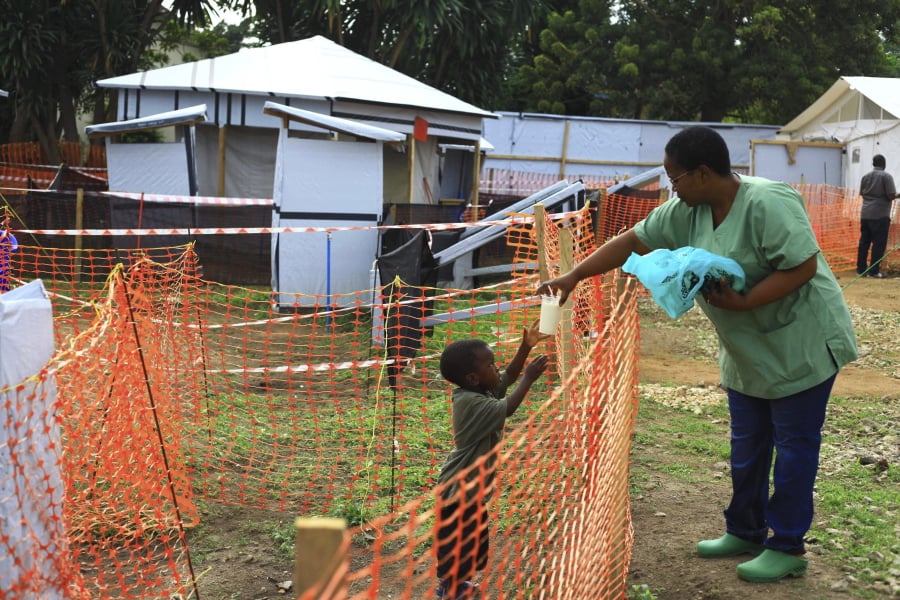 FILE - In this Sunday, Sept. 9, 2018 file photo, a health worker feeds a boy suspected of having the Ebola virus at an Ebola treatment centre in Beni, Eastern Congo. The World Health Organization says Ebola deaths in Congo’s latest outbreak are expected to exceed 1,000 later on Friday, May 3, 2019. WHO’s emergencies chief made the announcement at a news conference in Geneva. The Ebola outbreak that was declared in eastern Congo in August is already the second deadliest outbreak in history, and efforts to control it have been complicated by a volatile security situation and deep community mistrust.