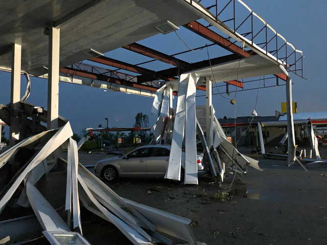 A car is trapped under the fallen metal roof of the Break Time gas station and convenience store in tornado-hit Jefferson City, MO., Thursday, May 23, 2019. The National Weather Service has confirmed a large and destructive tornado has touched down in Missouri's state capital, causing heavy damage and trapping multiple people in the wreckage of their homes. (AP Photo/David A.