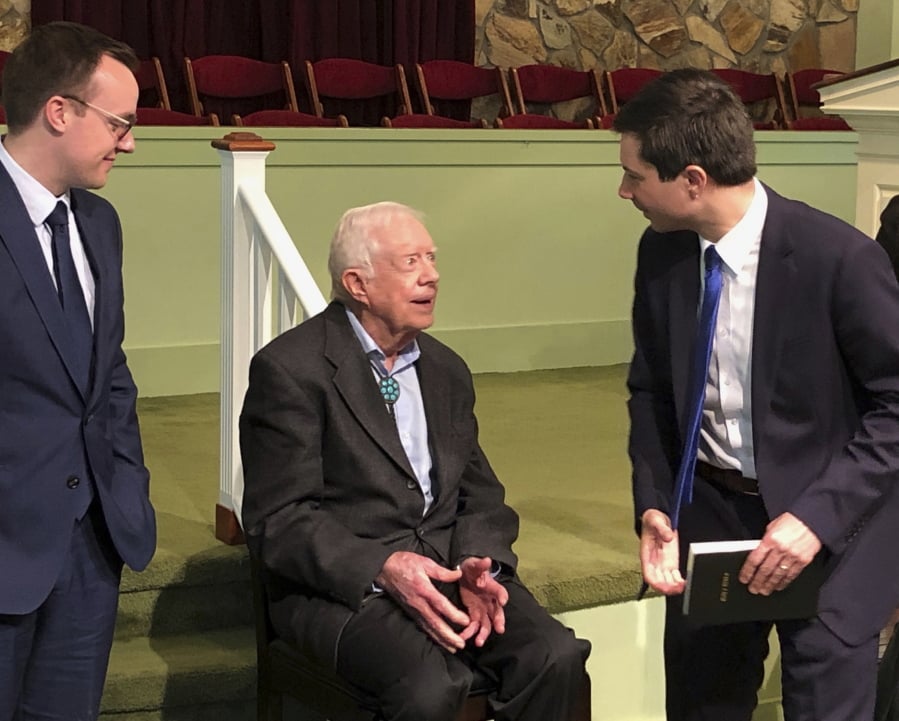 Democratic presidential candidate Pete Buttigieg, right, and his husband, Chasten Glezman, left, speak with former President Jimmy Carter Sunday at Carter’s Sunday school class in Plains, Ga.