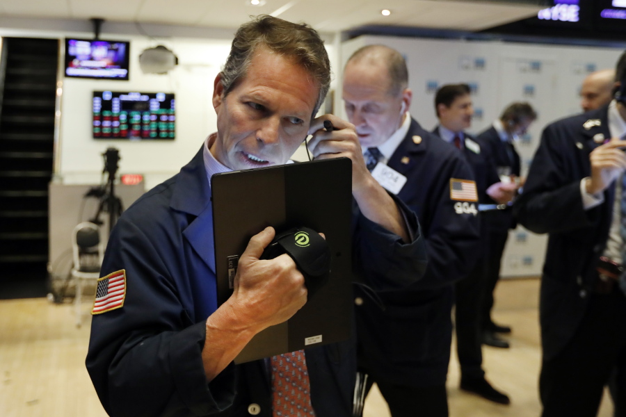 FILE - In this May 1, 2019, file photo, trader Robert Charmak, left, works on the floor of the New York Stock Exchange. On Monday, May 6, U.S. stocks plunged at the opening of trading, following a sell-off in global markets, after President Donald Trump threatened to escalate a trade war between the world’s two largest economies.