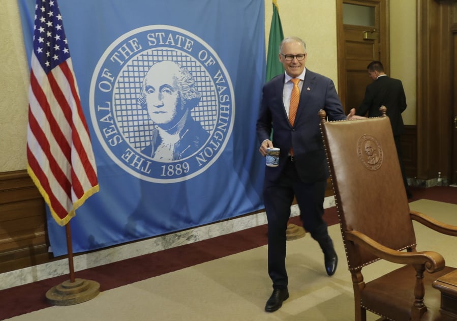 Washington Gov. Jay Inslee arrives to sign bills into law Tuesday, May 7, 2019, at the Capitol in Olympia, Wash. Included in the signings Tuesday were several gun-related bills, including expanding the state’s ability to keep guns away from people placed on psychiatric holds or found incompetent to stand trial. (AP Photo/Ted S.