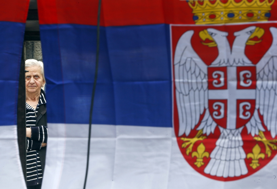 A Kosovo Serb woman is framed by Serbian flags as she attends a protest against Kosovo police action in the northern Serb-dominated part of ethnically divided town of Mitrovica, Kosovo, Wednesday, May 29, 2019. Russia and Serbia have blamed NATO and the West for an armed raid by Kosovo police in the Serb dominated north of Kosovo when a Russian U.N. employee was among more than two dozen people arrested in what Kosovo says was an anti-organized crime operation.