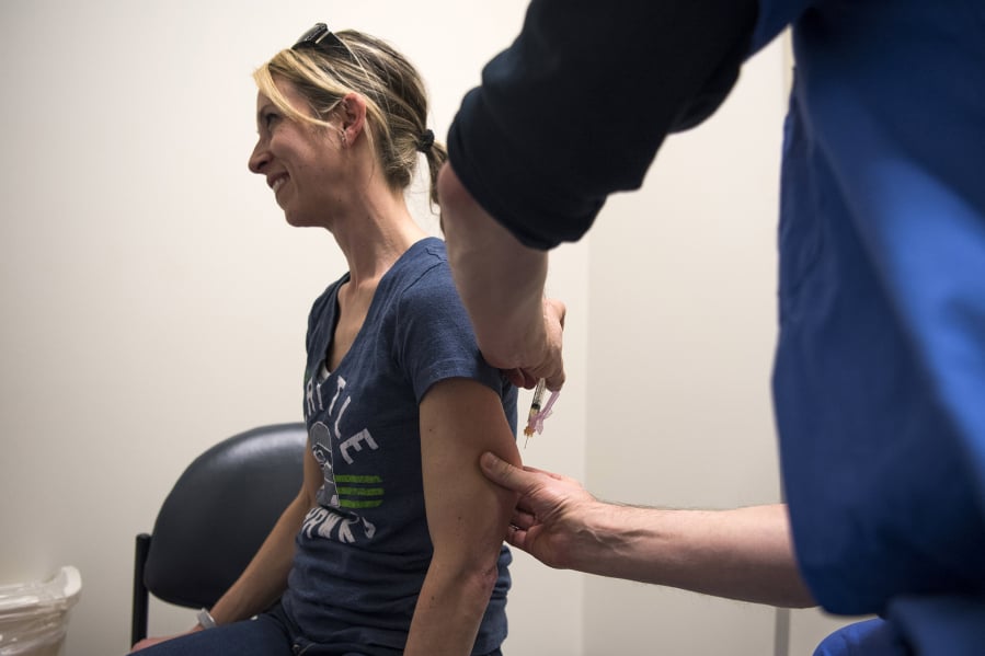 Julie Scordino of Camas holds still as registered nurse Kent Slawson administers the MMR vaccine during a free vaccination clinic offered by Legacy Medical Group in Vancouver. Legacy offered vaccination MMR vaccination clinics in March as a low barrier opportunity for vaccinations.