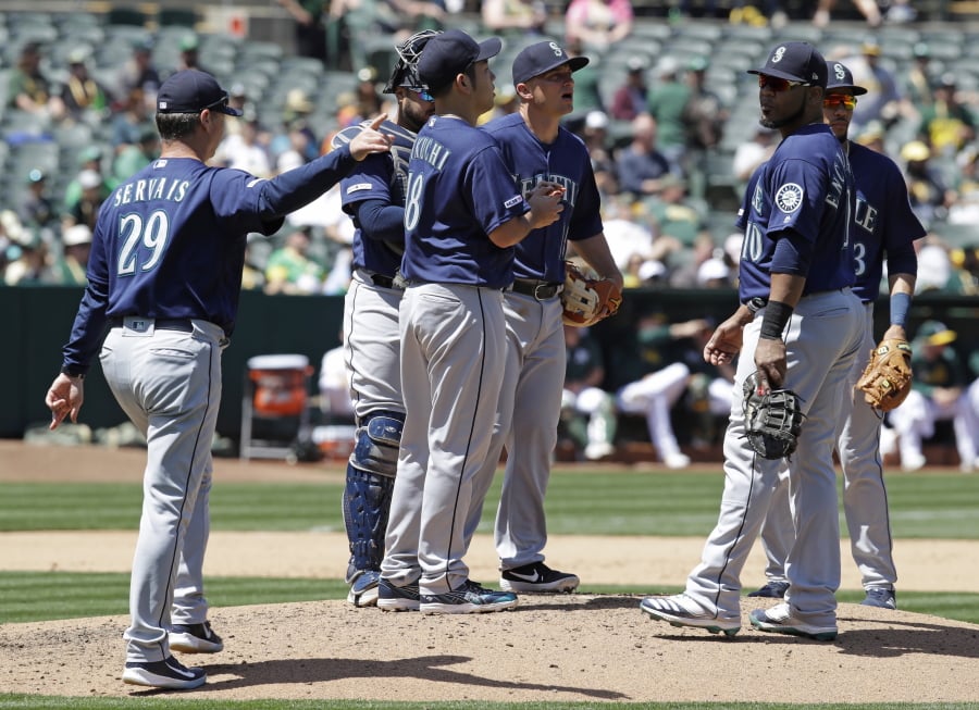 Seattle Mariners’ Scott Servais, left, calls for a new pitcher as Yusei Kikuchi, center, is removed in the fourth inning of a baseball game against the Oakland Athletics, Saturday, May 25, 2019, in Oakland, Calif.
