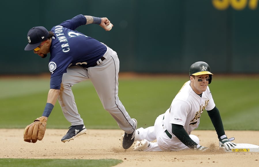 Oakland Athletics’ Mark Canha, right, breaks up a double play with Seattle Mariners’ J.P. Crawford, left, in the seventh inning of a baseball game Sunday, May 26, 2019, in Oakland, Calif.