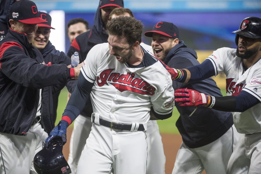 Cleveland Indians’ Tyler Naquin, center, is mobbed by teammates after hitting a winning RBI-single off Seattle Mariners relief pitcher Anthony Swarzak in the ninth inning of a baseball game in Cleveland, Friday, May 3, 2019.