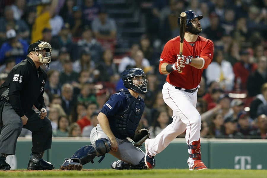 Boston Red Sox’s Mitch Moreland, right, follows through on his three-run home run in front of Seattle Mariners’ Tom Murphy during the third inning of a baseball game in Boston, Friday, May 10, 2019.