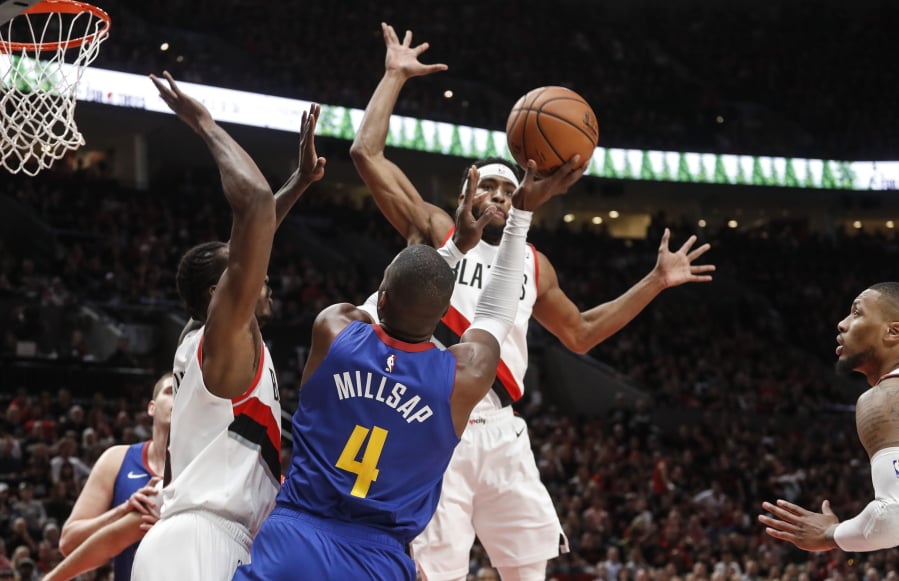 Denver Nuggets forward Paul Millsap,shoots over Portland Trail Blazers defenders during the first half of Game 6 of an NBA basketball second-round playoff series Thursday, May 9, 2019, in Portland, Ore.