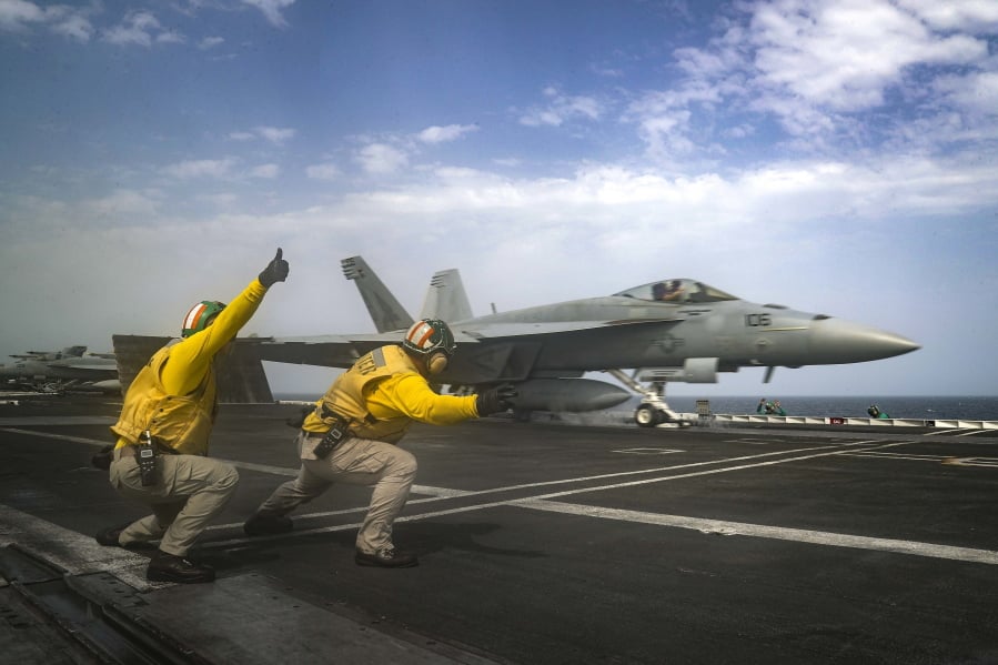 In this Thursday, May 16, 2019 photo released by the U.S. Navy, Lt. Nicholas Miller, from Spring, Texas, and Lt. Sean Ryan, from Gautier, Miss., launch an F-18 Super Hornet from the deck of the USS Abraham Lincoln aircraft carrier in the Arabian Sea. On Saturday, May 18, 2019, (Mass Communication Specialist 3rd Class Jeff Sherman, U.S.