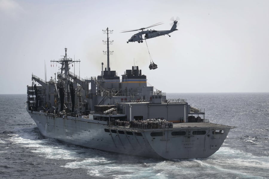 In this Sunday, May 19, 2019, photo released by the U.S. Navy, an MH-60S Sea Hawk helicopter from the “Nightdippers” of Helicopter Sea Combat Squadron 5 transports cargo from the fast combat support ship USNS Arctic to the Nimitz-class aircraft carrier USS Abraham Lincoln during a replenishment-at-sea in the Arabian Sea.(Mass Communication Specialist 3rd Class Jeff Sherman/U.S.