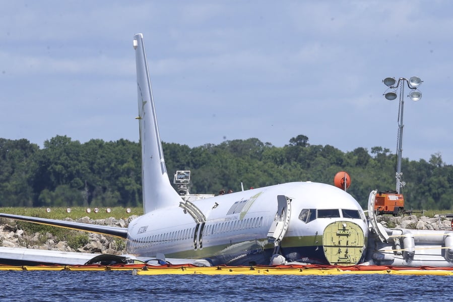 A charter plane carrying 143 people and traveling from Cuba to north Florida sits in a river at the end of a runway, Saturday, May 4, 2019 in Jacksonville, Fla. The Boeing 737 arriving at Naval Air Station Jacksonville from Naval Station Guantanamo Bay, Cuba, with 136 passengers and seven aircrew slid off the runway Friday night into the St. Johns River, a NAS Jacksonville news release said.