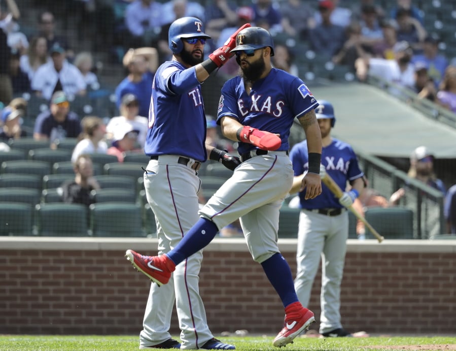 Texas Rangers’ Nomar Mazara, left, and Rougned Odor, right, react after they both scored on a two-run single hit by Shin-Soo Choo during the eighth inning of a baseball game against the Seattle Mariners, Wednesday, May 29, 2019, in Seattle. The Rangers won 8-7. (AP Photo/Ted S.