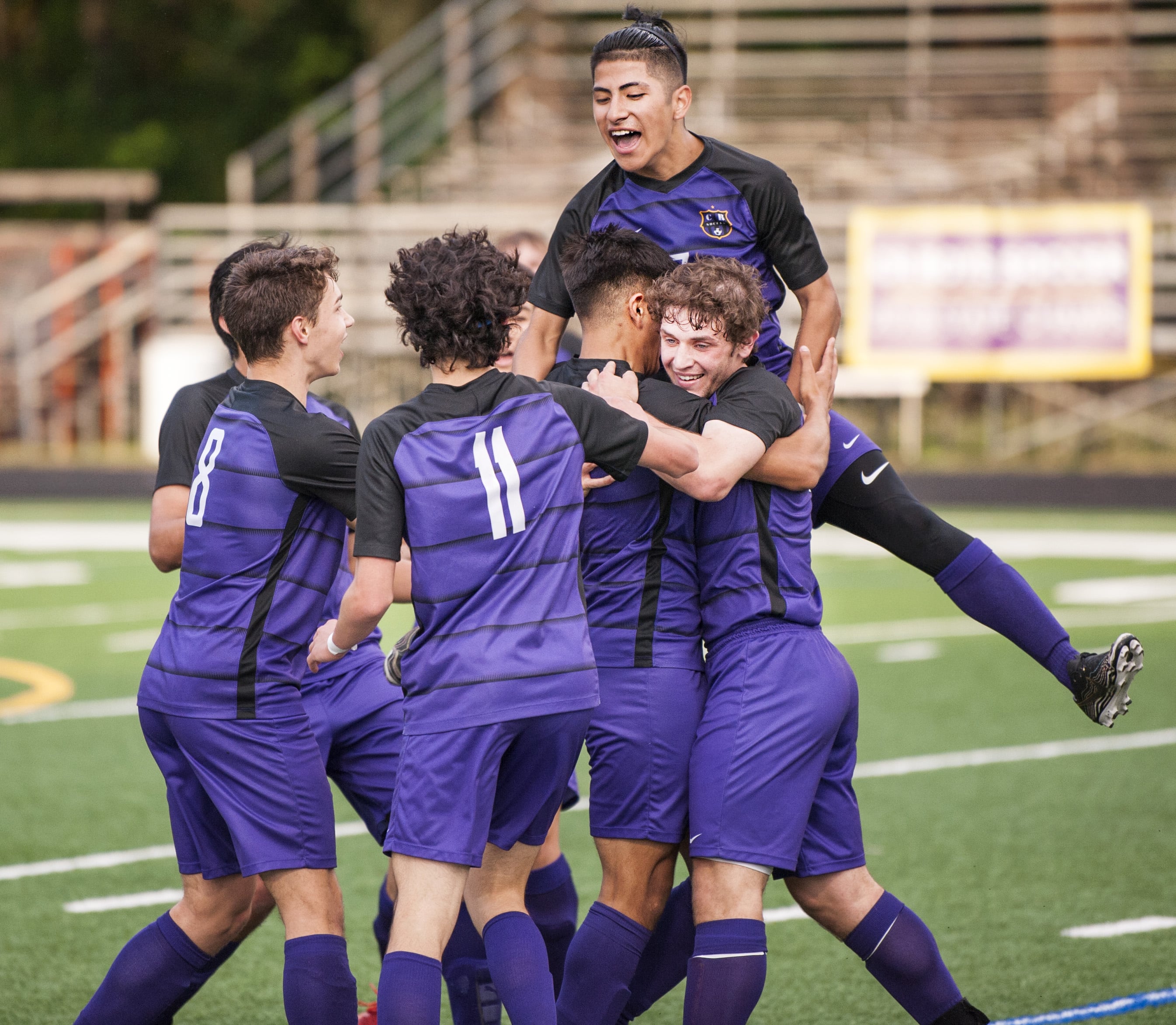 Columbia River's Julian Villa-Salas, top, jumps into a pile centered around Aaron Espinosa and Jake Connop after Espinosa' 35th-minute goal in a 2A State first-round game Tuesday at Chieftain Stadium. Columbia River won 3-1.
