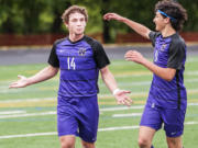 Columbia River's Jake Connop gestures toward his teammates as Sideris Kosaris comes to congratulate him on his second goal of a 2A state quarterfinal game Saturday at Chieftain Stadium. Columbia River won 4-1.