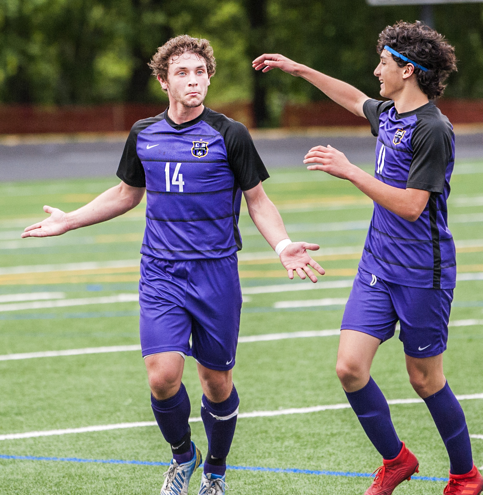 Columbia River's Jake Connop gestures toward his teammates as Sideris Kosaris comes to congratulate him on his second goal of a 2A state quarterfinal game Saturday at Chieftain Stadium. Columbia River won 4-1.