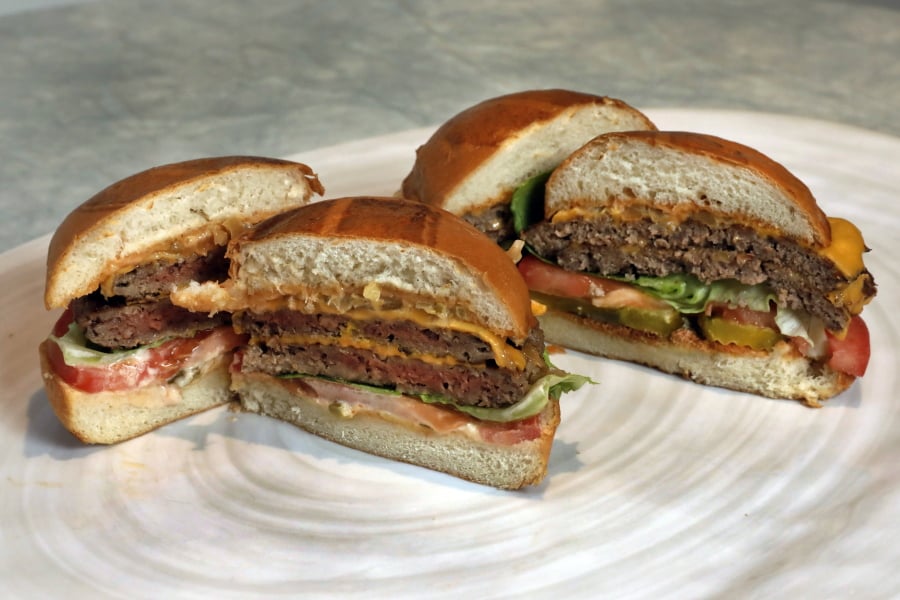 An Original Impossible Burger, left, and a Cali Burger, from Umami Burger, are shown in this photo in New York, Friday, May 3, 2019. A new era of meat alternatives is here, with Beyond Meat becoming the first vegan meat company to go public and Impossible Burger popping up on menus around the country.