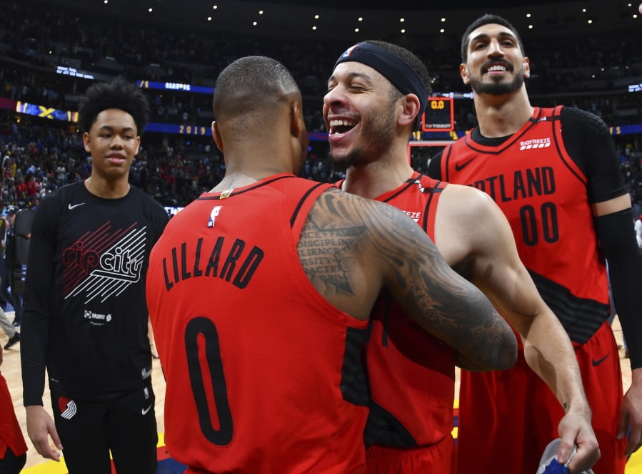 From front, Portland Trail Blazers guard Damian Lillard celebrates with guard Seth Curry and center Enes Kanter after the second half of Game 7 of an NBA basketball second-round playoff series Sunday, May 12, 2019, in Denver. The Trail Blazers won 100-96.