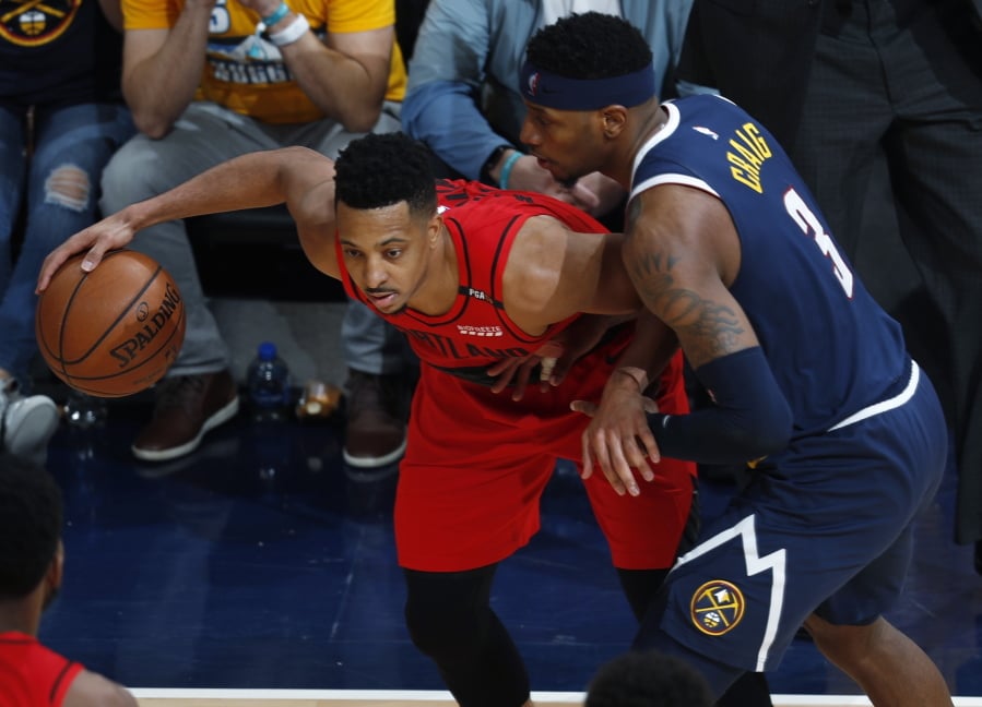 Portland Trail Blazers guard CJ McCollum, left, looks to pass the ball as Denver Nuggets forward Torrey Craig defends in the second half of Game 7 of an NBA basketball second-round playoff series Sunday, May 12, 2019, in Denver. The Trail Blazers won 100-96.