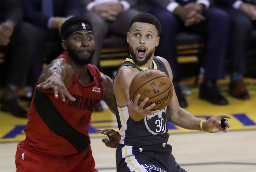 Golden State Warriors guard Stephen Curry, right, shoots as Portland Trail Blazers forward Maurice Harkless defends during the second half of Game 2 of the NBA basketball playoffs Western Conference finals in Oakland, Calif., Thursday, May 16, 2019.