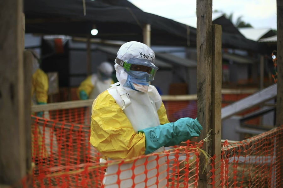 FILE - In this Tuesday April, 16, 2019 file photo, an Ebola health worker is seen at a treatment center in Beni, Eastern Congo. Internal documents by The Associated Press show the World Health Organization spent nearly $192 million on travel last year, with staffers sometimes breaking the rules by flying in business class, booking expensive last-minute tickets and traveling without the required approvals.