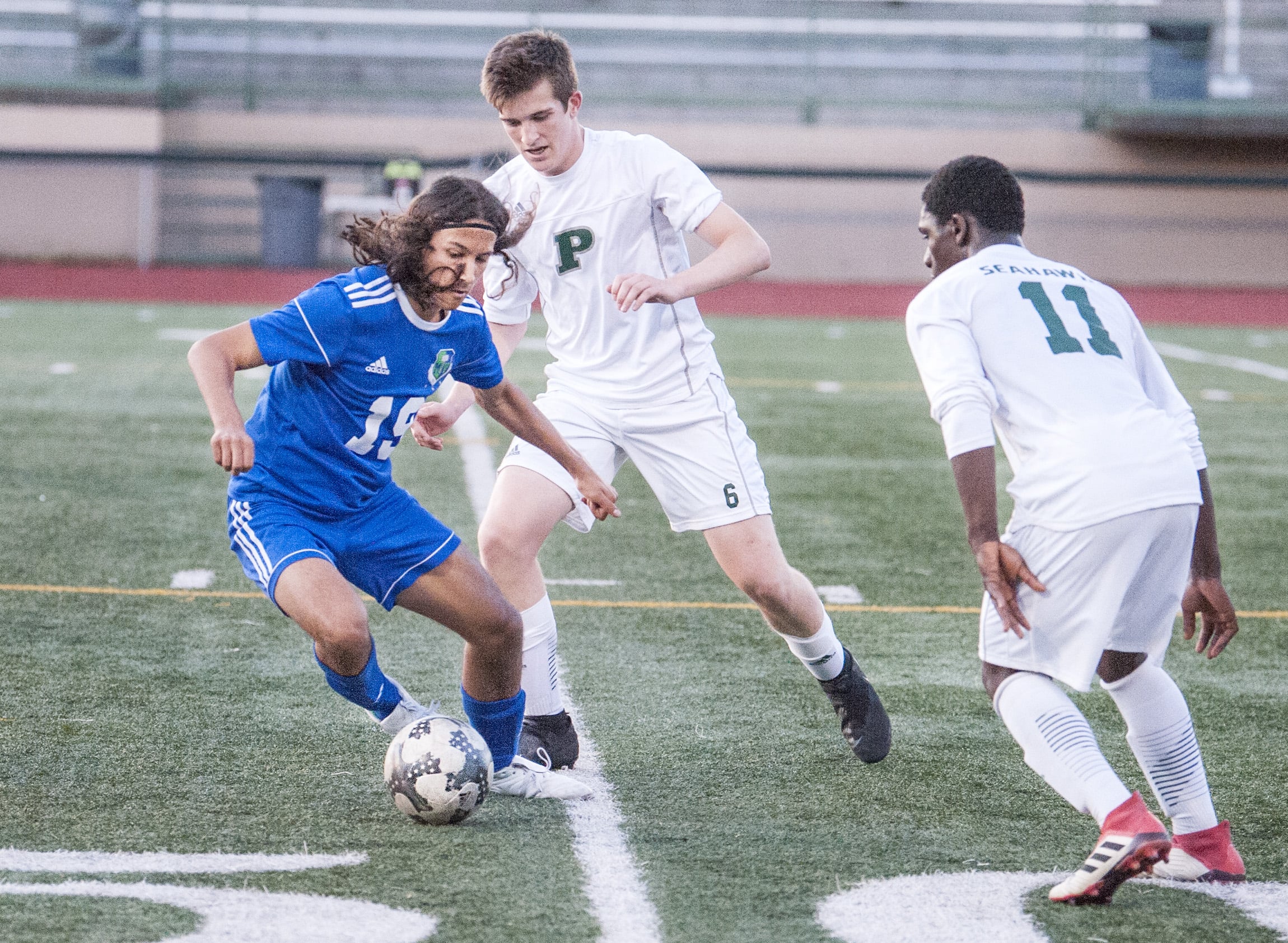 Mountain View's Elijah Thompson, left sidesteps Pensinsula's Austin Lee, back, and Kenneh Roberts in a 3A bi-district boys soccer game Tuesday at McKenzie Stadium. Peninsula won 2-1.