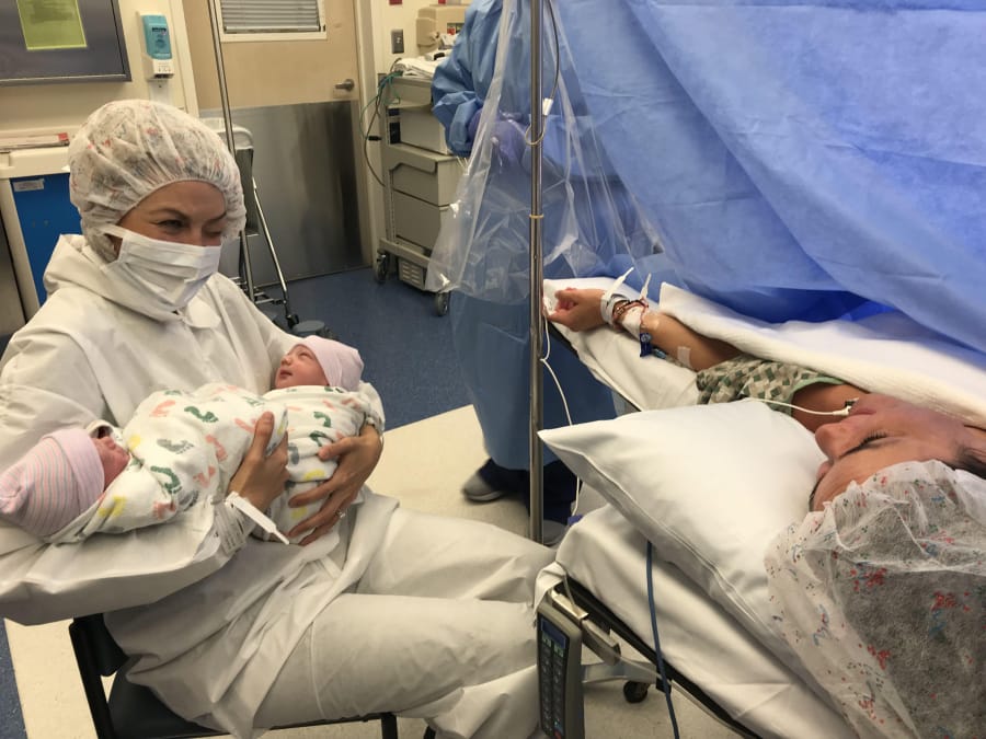 Whitney Bliesner, left, holds her newborn children Rhett and Rhenley after her sister, Jill Noe, right, gave birth to them June 7 in Portland.