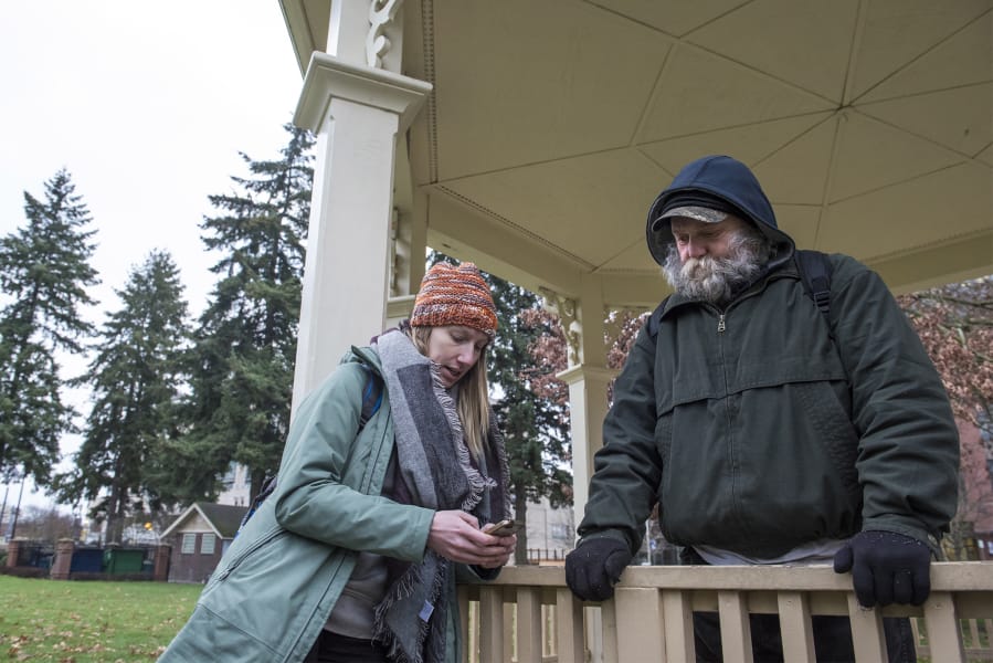 Katelyn Benhoff, lead outreach case manager with Share, left, speaks with a man who declined to give his name while performing the annual Point in Time Count on Jan. 24 in Vancouver’s Esther Short Park.