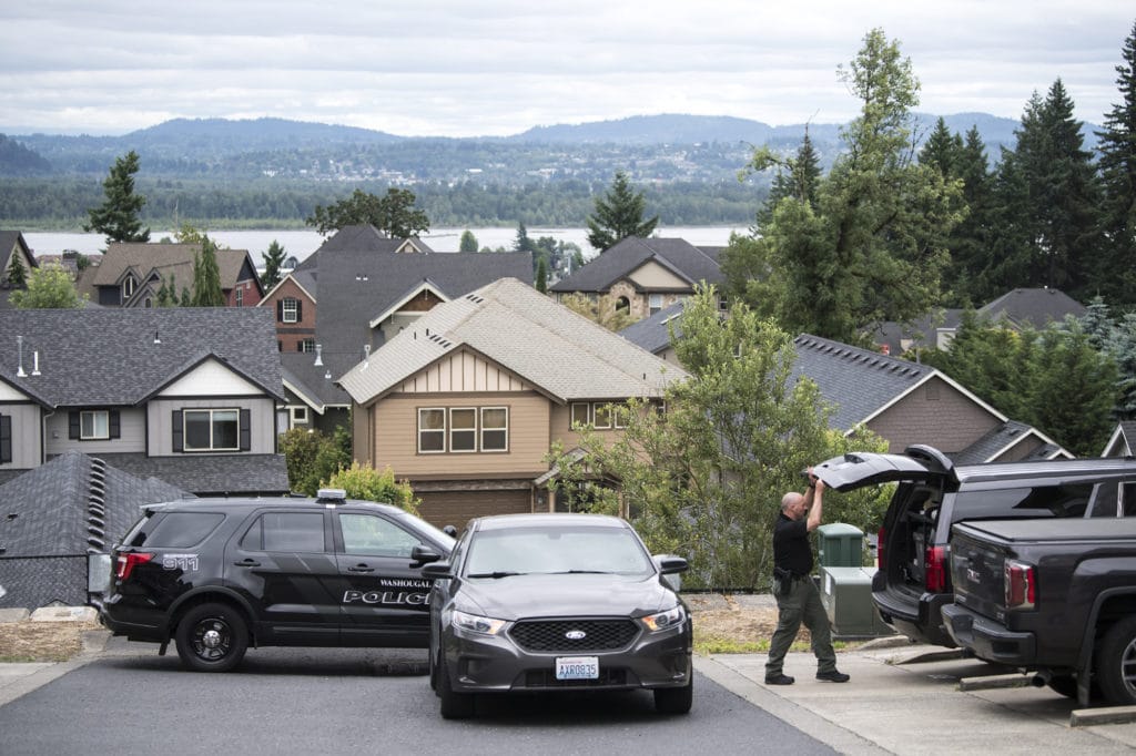 A Clark County Sheriff's Investigator searches his vehicle for gear while investigating a stabbing assault on West Lookout Ridge Drive in Washougal on Tuesday morning, June 18, 2109.