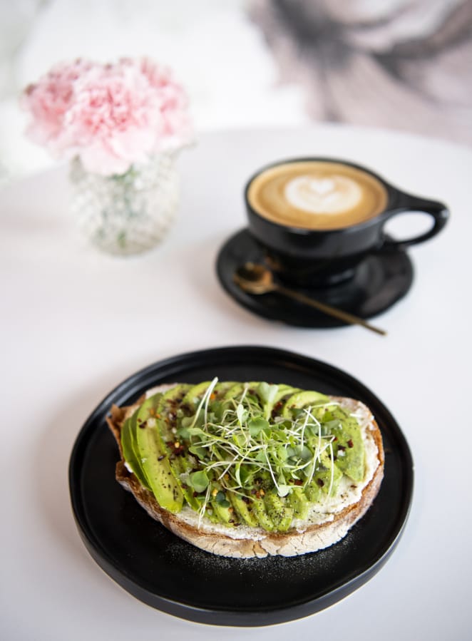 The avocado toast at Presso Coffee Kitchen. The rustic white bread is topped with ricotta cheese, avocado, olive oil, lemon juice, salt, pepper, chili flakes and micro greens.