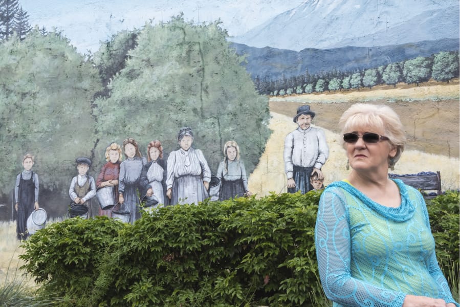 Sharon York looks past a mural of her ancestors, the Wishon family, while talking with her sisters at Orchards Plaza.