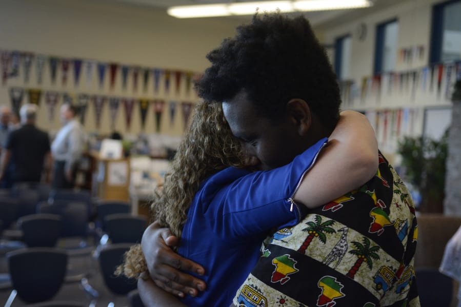 Hockinson Superintendent Sandra Yager hugs Mussè Barclay, 17, at a farewell party Monday night. Yager is leaving the district after 17 years, the last eight as superintendent. She has had an impact on plenty of students, including Barclay, who said she made him feel welcome in the area after he was adopted from Ethiopia.