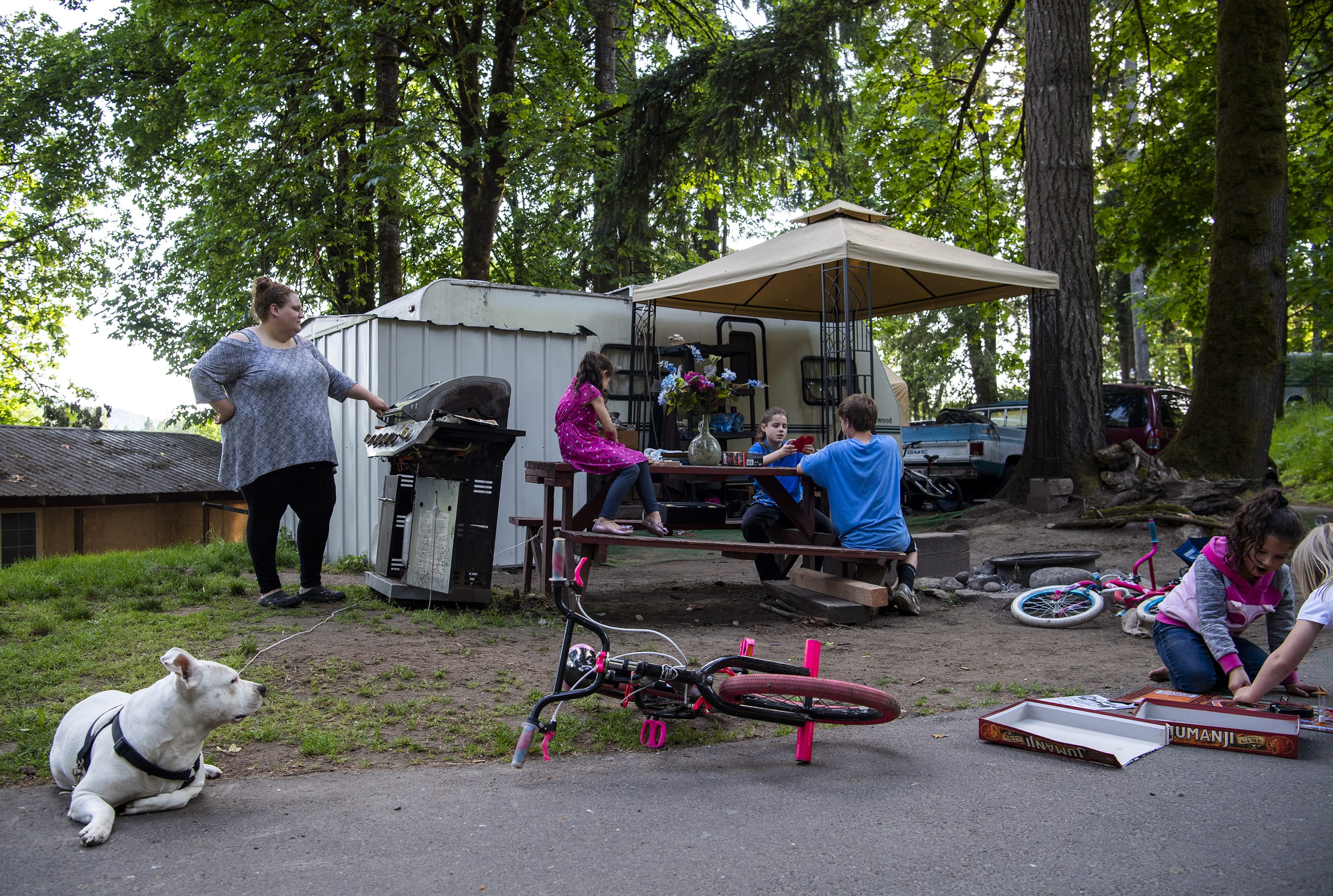 Valerie Guerra, left, barbecues meat and vegetables for her kids outside their RV at the Lewis River RV Park in Woodland on May 29, 2019. A few years ago Valerie’s husband was injured at work and Valerie lost her job. At the same time, they also received a 20-day notice to vacate their rental. After being unsheltered and hotel hopping, the family decided to stay in an RV. Valerie and her husband are both working again and the family is hoping to find housing by the end of the year.