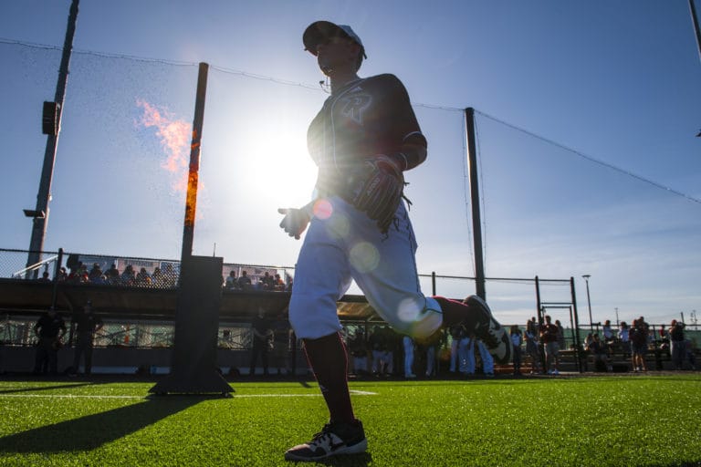 A Raptors' player runs onto the field past a column of fire before their match against Yakima at the Ridgefield Outdoor Recreation Center on Tuesday night, June 4, 2019.