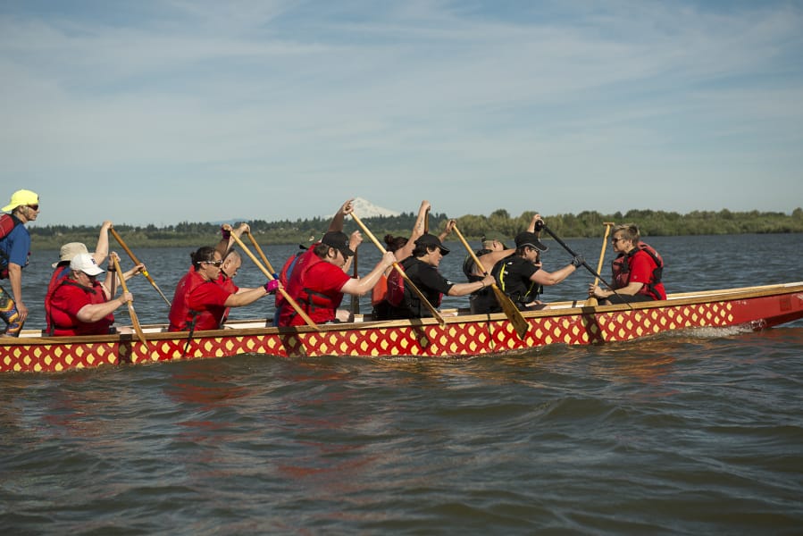 Representatives of Kleen Street Recovery Cafe, a group that helps people with substance abuse recovery, and members of Peace Lutheran Church paddle a dragon boat Monday in preparation for the July 13 Paddle For Life event at Vancouver Lake Regional Park.