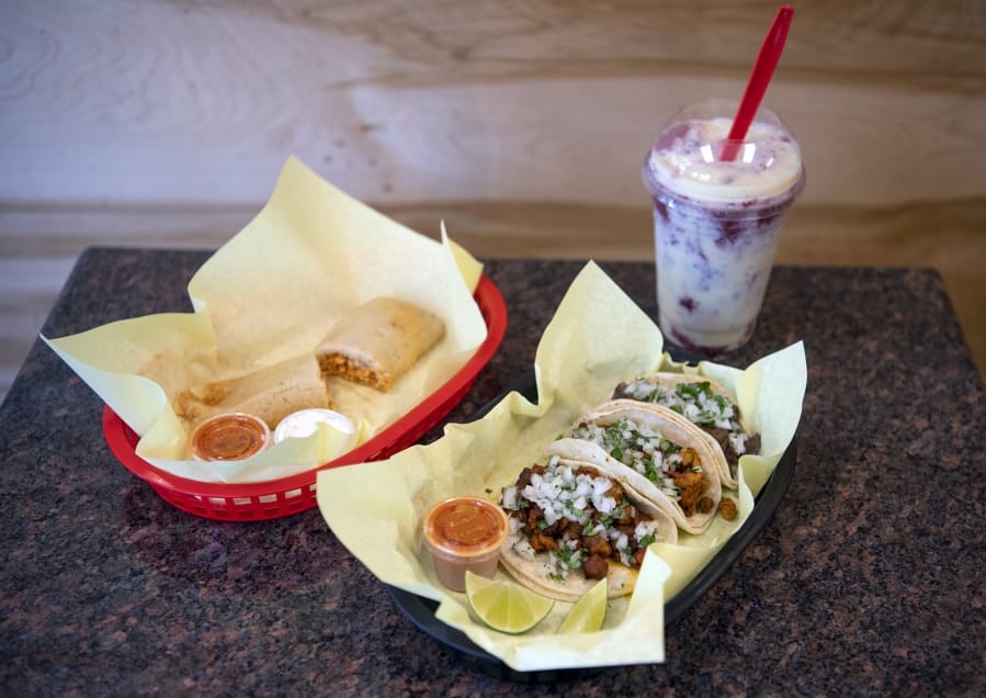 A chicken tamale, left, carne asada, pollo, and al pastor tacos, center, and a strawberry Raspados drink, right, are pictured at El Buen Gusto in Vancouver on Friday, June 14, 2019.
