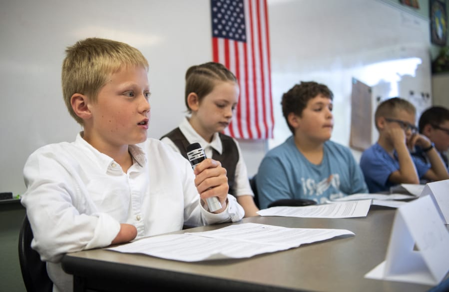 Fifth-grader Lason Spencer, left, answers a question during a mock congressional hearing Wednesday at Tukes Valley Middle School in Battle Ground. Through the We the People curriculum, students learn about history with hands-on lessons, such as Wednesday’s presentation.